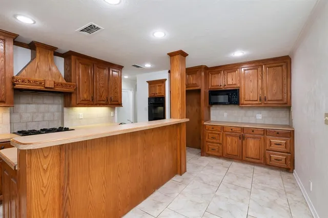 a kitchen with stainless steel appliances granite countertop wooden cabinets a stove top oven a sink and dishwasher