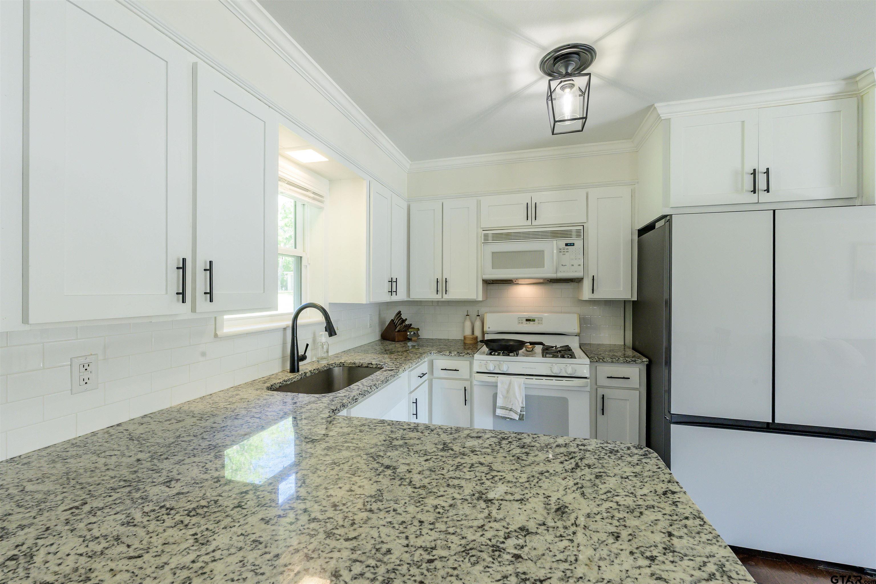 5921 Springbrook Drive Tyler, TX 75707 - Photo 11 of 39 a kitchen with a stove a sink and a refrigerator