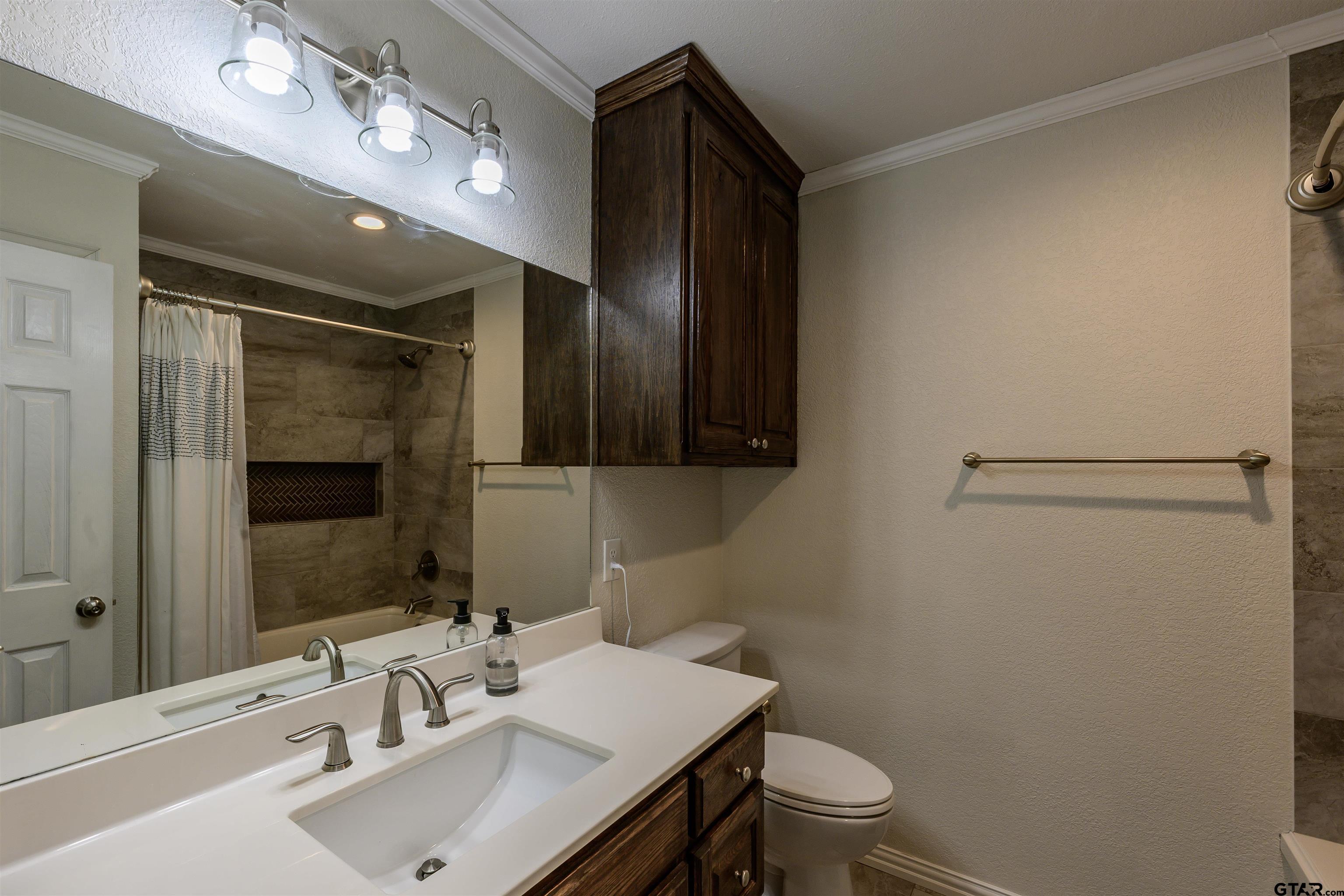 5921 Springbrook Drive Tyler, TX 75707 - Photo 16 of 39 a bathroom with a sink a toilet a mirror and shower