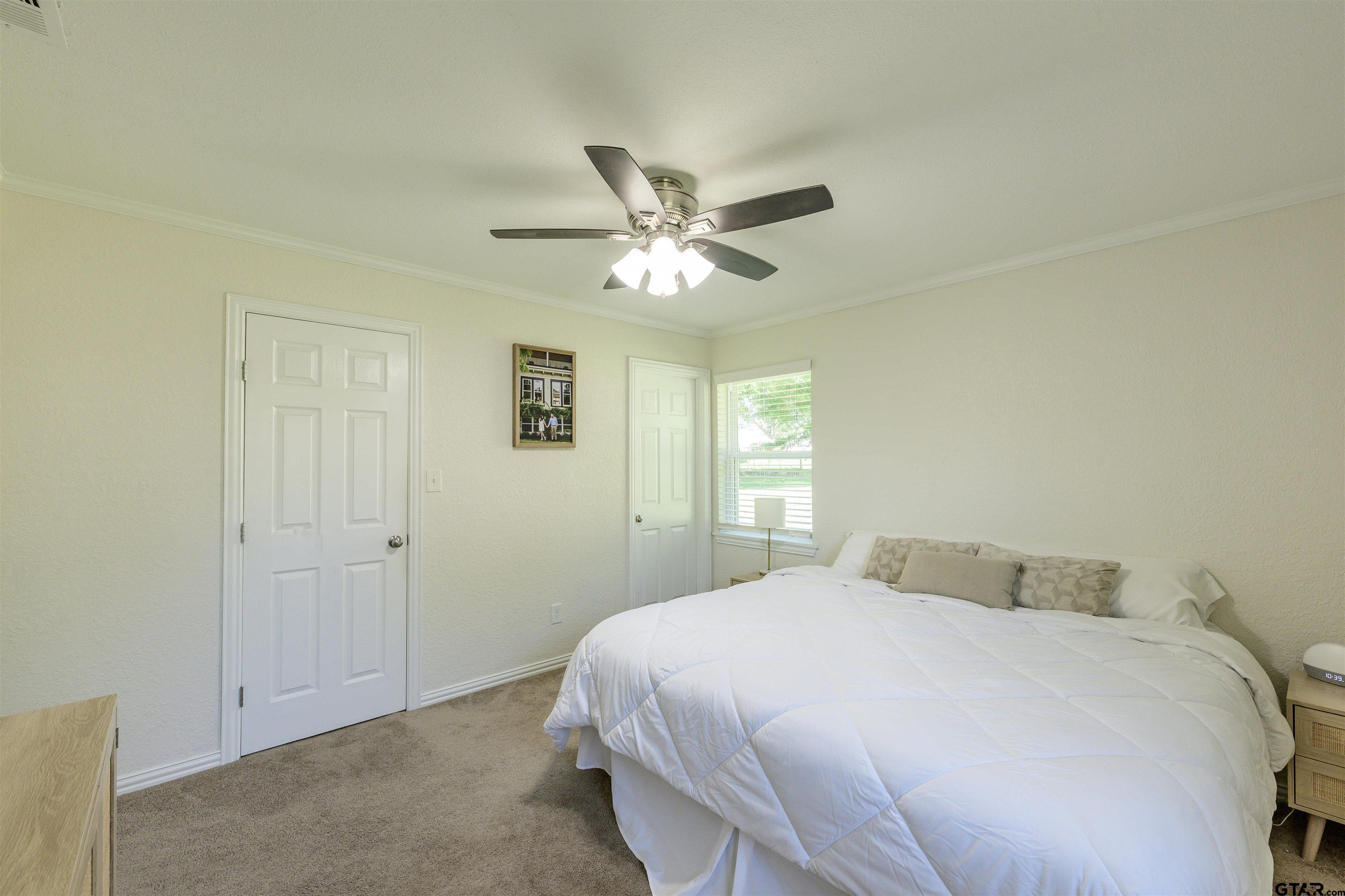 5921 Springbrook Drive Tyler, TX 75707 - Photo 28 of 39 a bedroom with a bed and a ceiling fan
