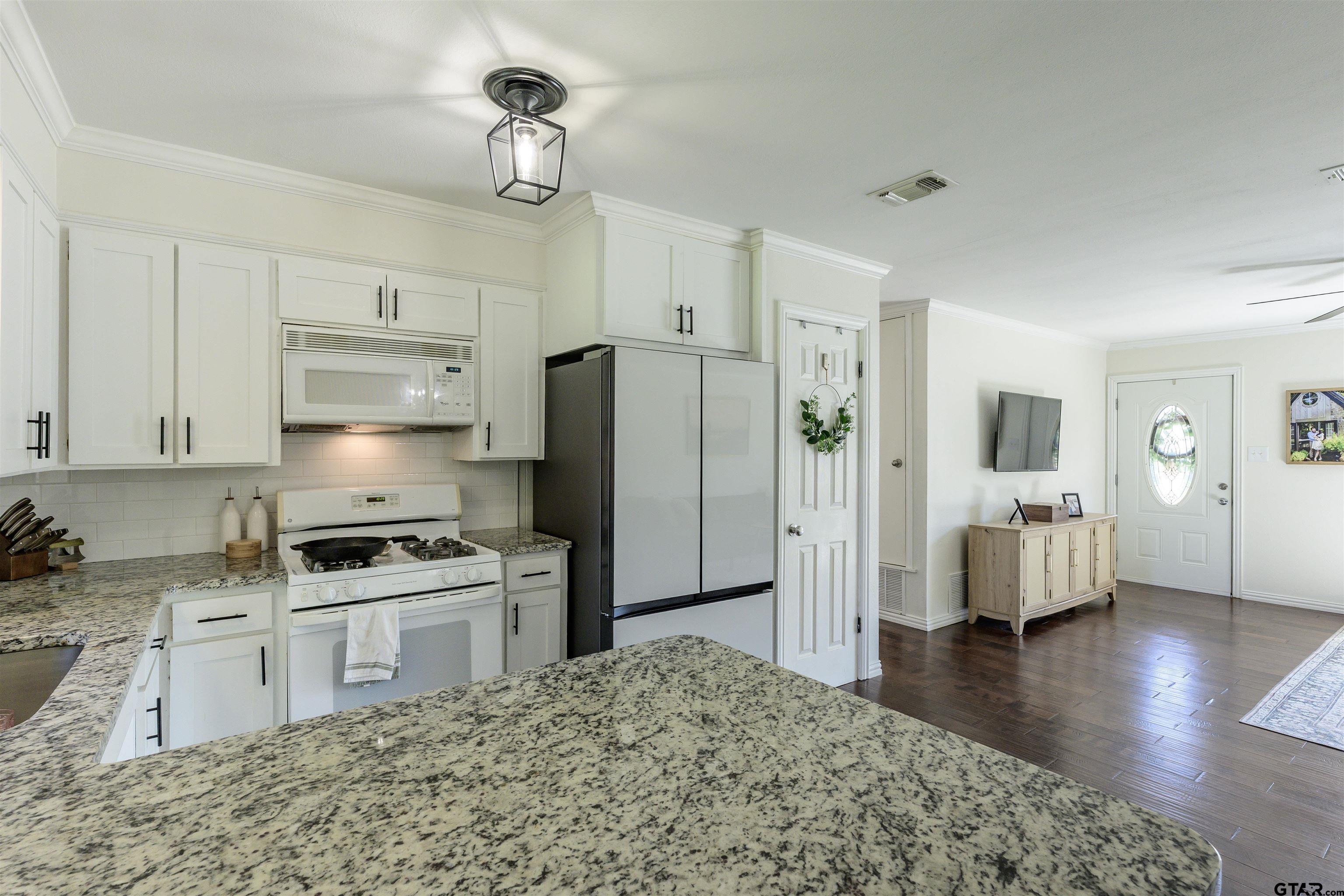 5921 Springbrook Drive Tyler, TX 75707 - Photo 10 of 39 a kitchen with stainless steel appliances granite countertop a refrigerator stove oven and white cabinets