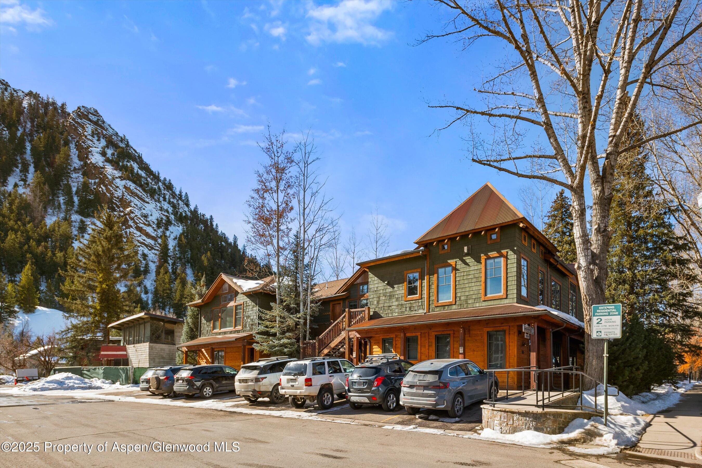 503 West Main Street, Unit B202 Aspen, CO 81611 - Photo 20 of 22 a front view of a building with lot of cars and trees
