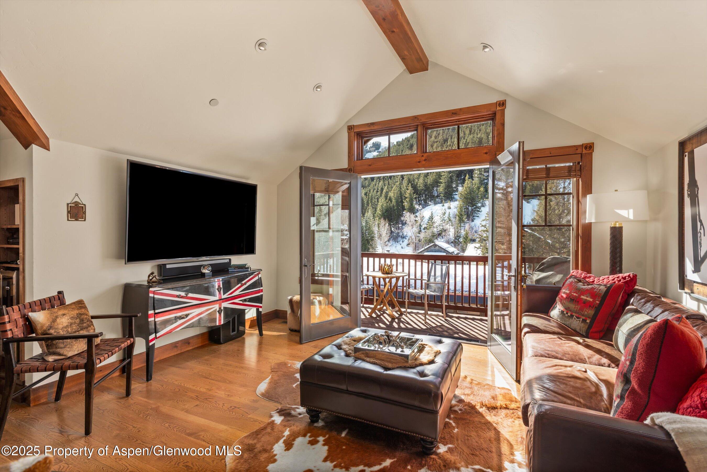 503 West Main Street, Unit B202 Aspen, CO 81611 - Photo 3 of 22 a living room with furniture a flat screen tv and floor to ceiling window