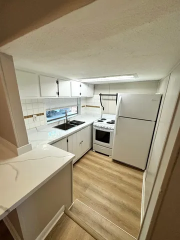 a kitchen with white cabinets and white appliances
