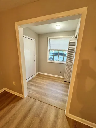 an empty room with wooden floor and windows