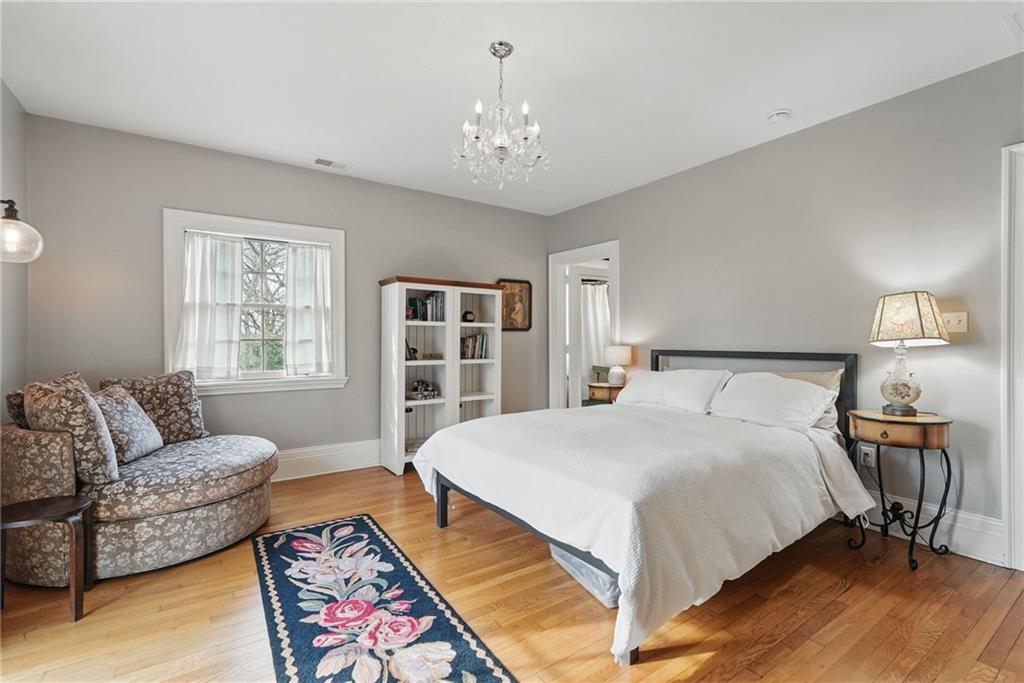 743 Chestnut Road Sewickley, PA 15143 - Photo 25 of 40 a spacious bedroom with a bed a couch and a chandelier