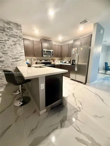a kitchen with a sink stainless steel appliances and cabinets