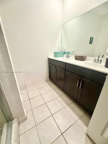 a bathroom with a sink vanity and mirror