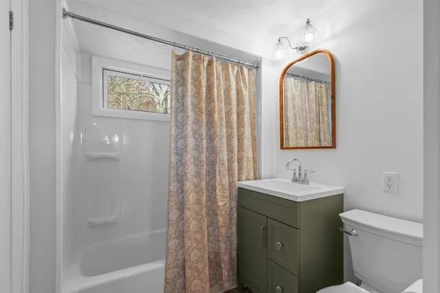 a bathroom with a toilet sink and mirror
