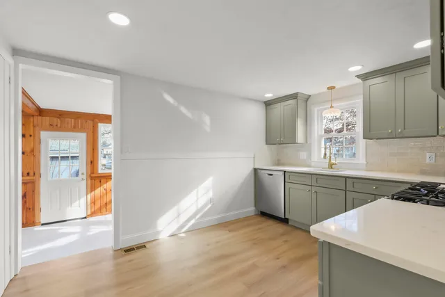 a kitchen with a sink cabinets and wooden floor
