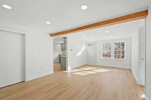 a view of an empty room and window and wooden floor