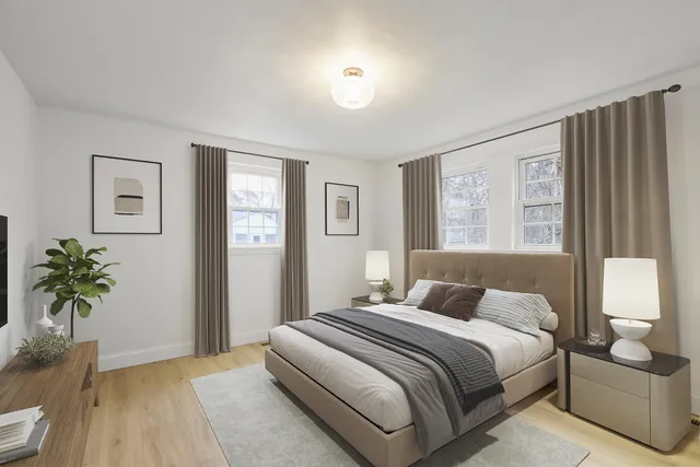 a bedroom with a large bed and a potted plant