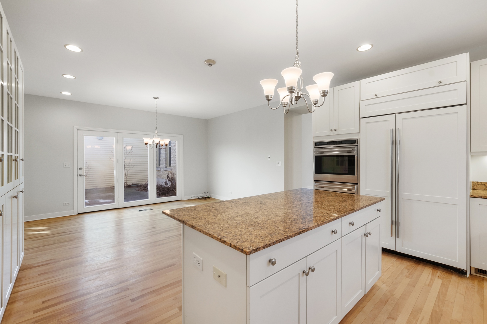 105 Ronan Road Highwood, IL 60040 - Photo 7 of 21 a kitchen with stainless steel appliances granite countertop a refrigerator a stove and white cabinets with wooden floor