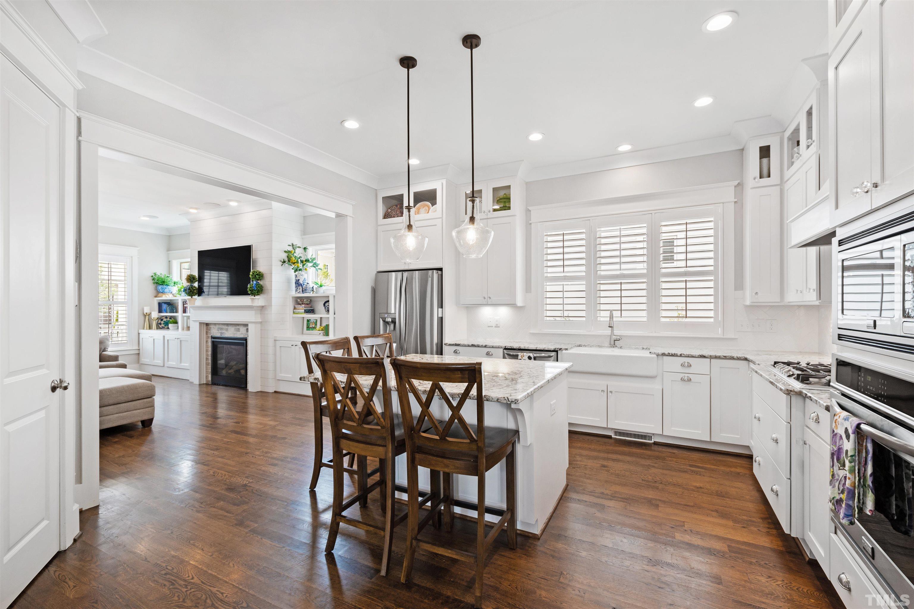721 Virginia Avenue Raleigh, NC 27604 - Photo 14 of 49 a kitchen with stainless steel appliances granite countertop wooden floor dining table and chairs
