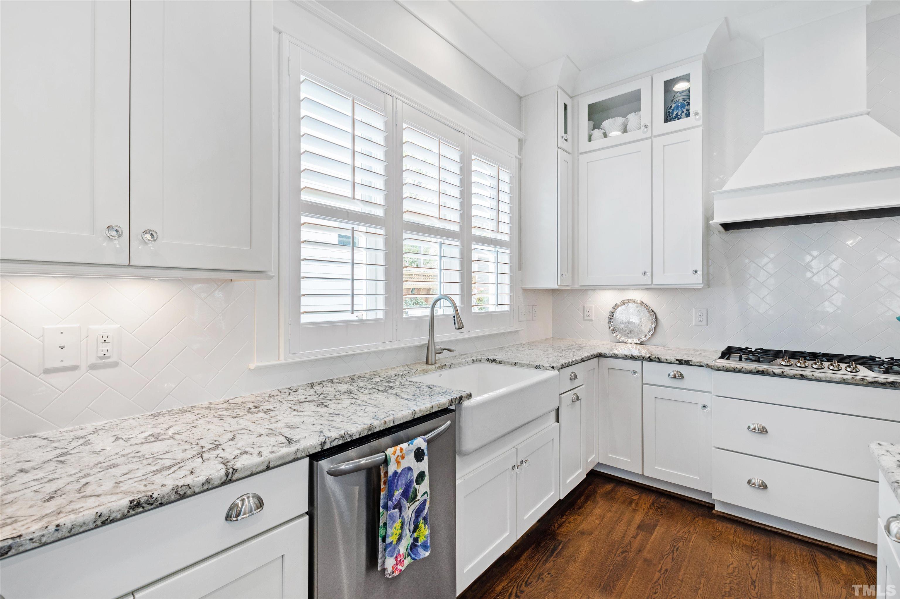 721 Virginia Avenue Raleigh, NC 27604 - Photo 15 of 49 a kitchen with granite countertop white cabinets sink and dishwasher with wooden floor