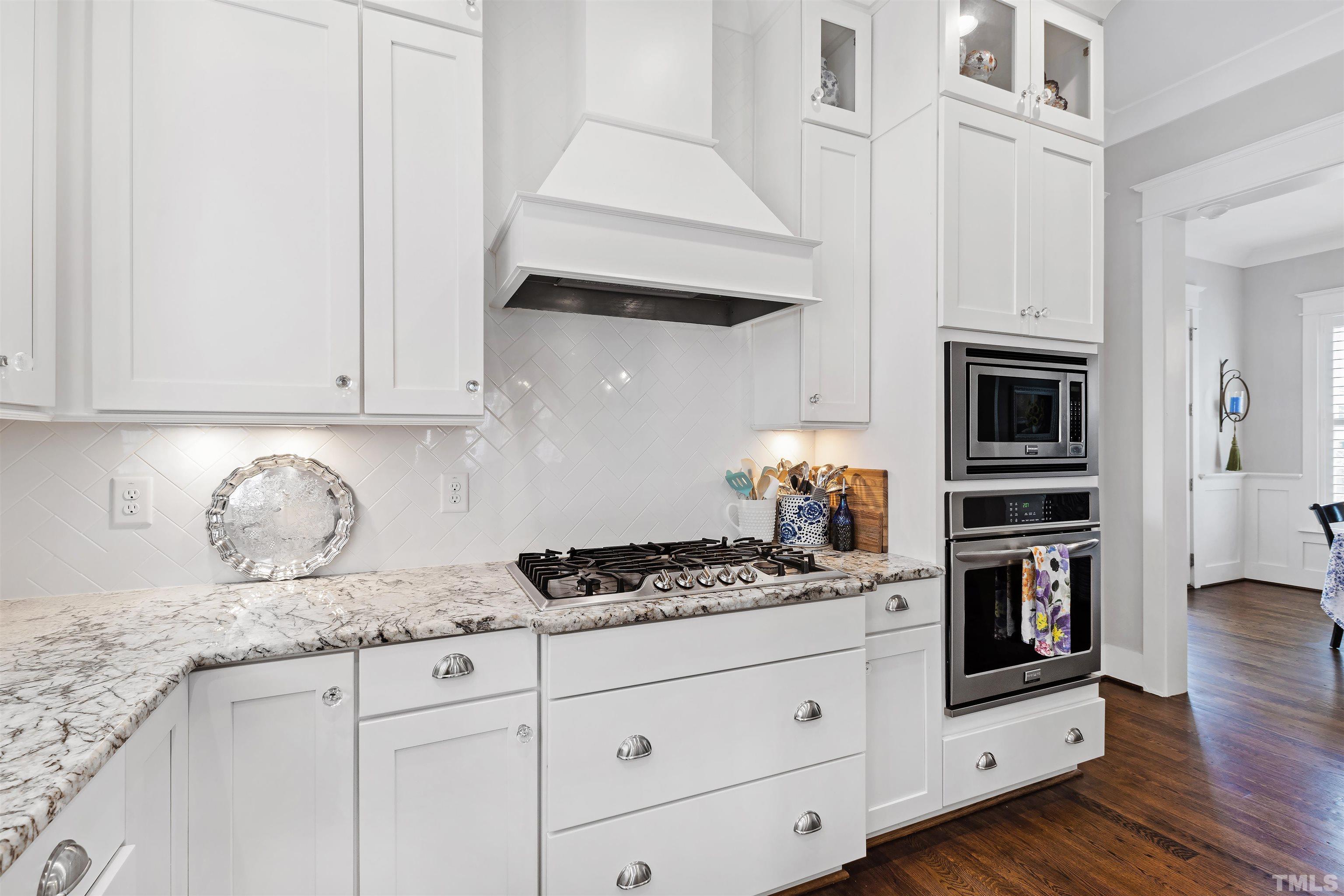721 Virginia Avenue Raleigh, NC 27604 - Photo 16 of 49 a kitchen with granite countertop white cabinets and stainless steel appliances