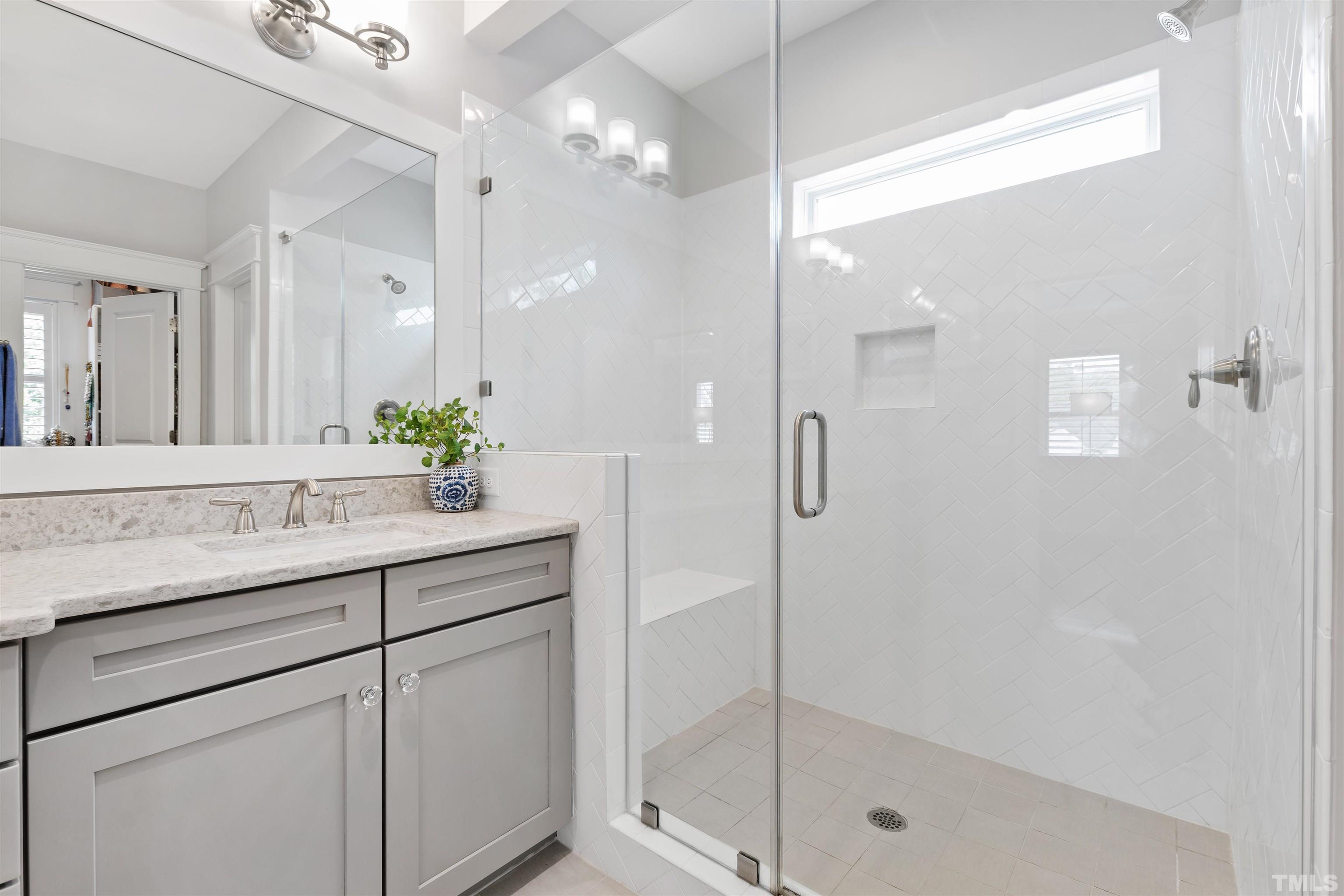 721 Virginia Avenue Raleigh, NC 27604 - Photo 28 of 49 a bathroom with a granite countertop sink a mirror and a shower