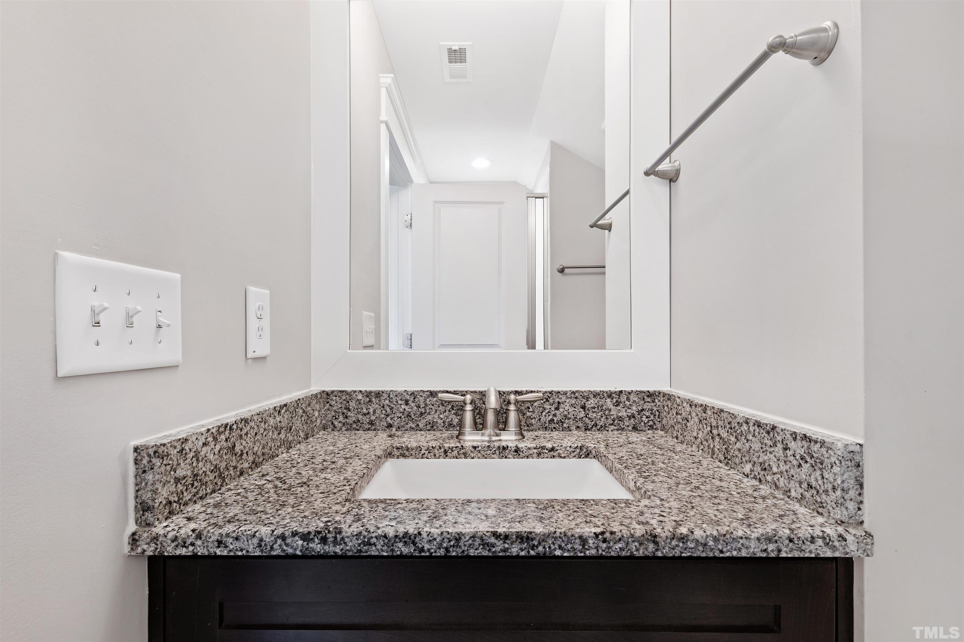 721 Virginia Avenue Raleigh, NC 27604 - Photo 41 of 49 a bathroom with a granite countertop sink and a mirror
