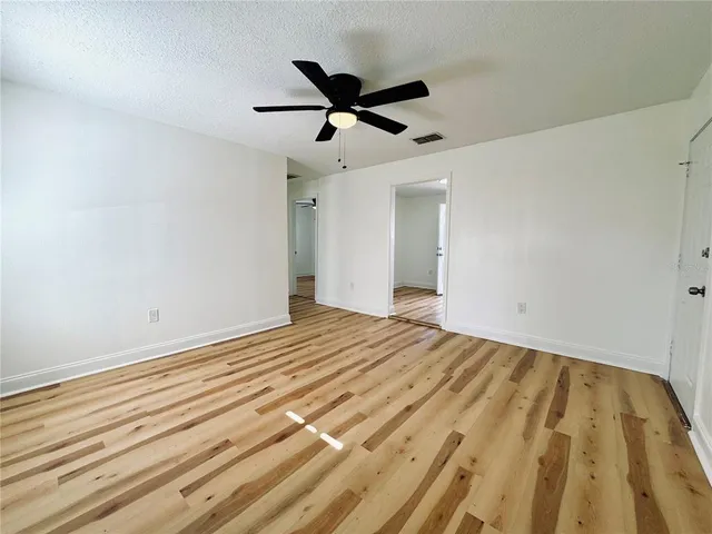 a view of empty room with wooden floor