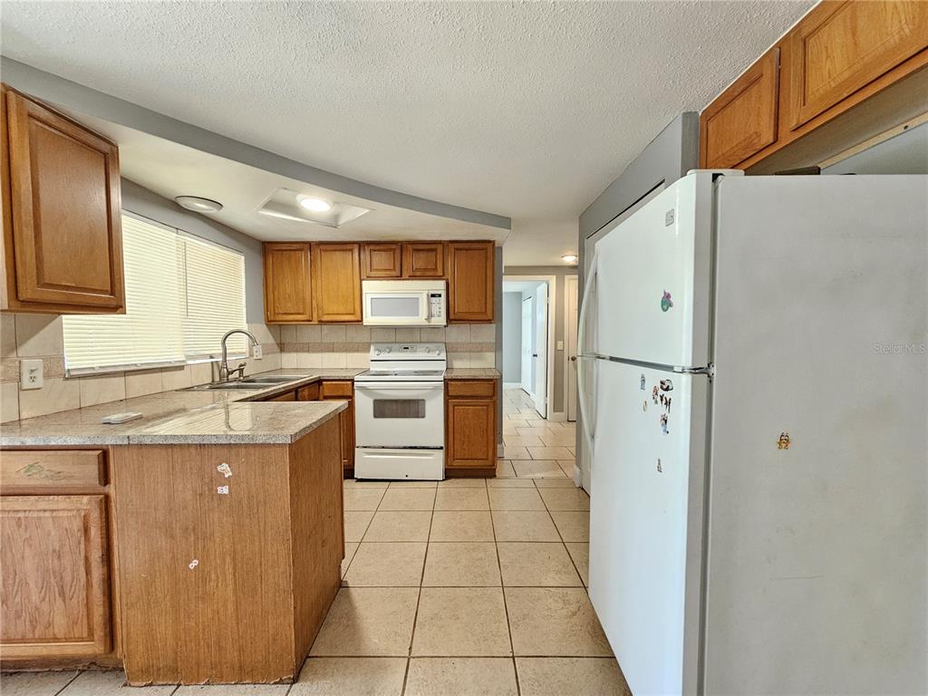 9210 Pegasus Avenue Port Richey, FL 34668 - Photo 7 of 19 a kitchen with stainless steel appliances granite countertop a refrigerator and a stove