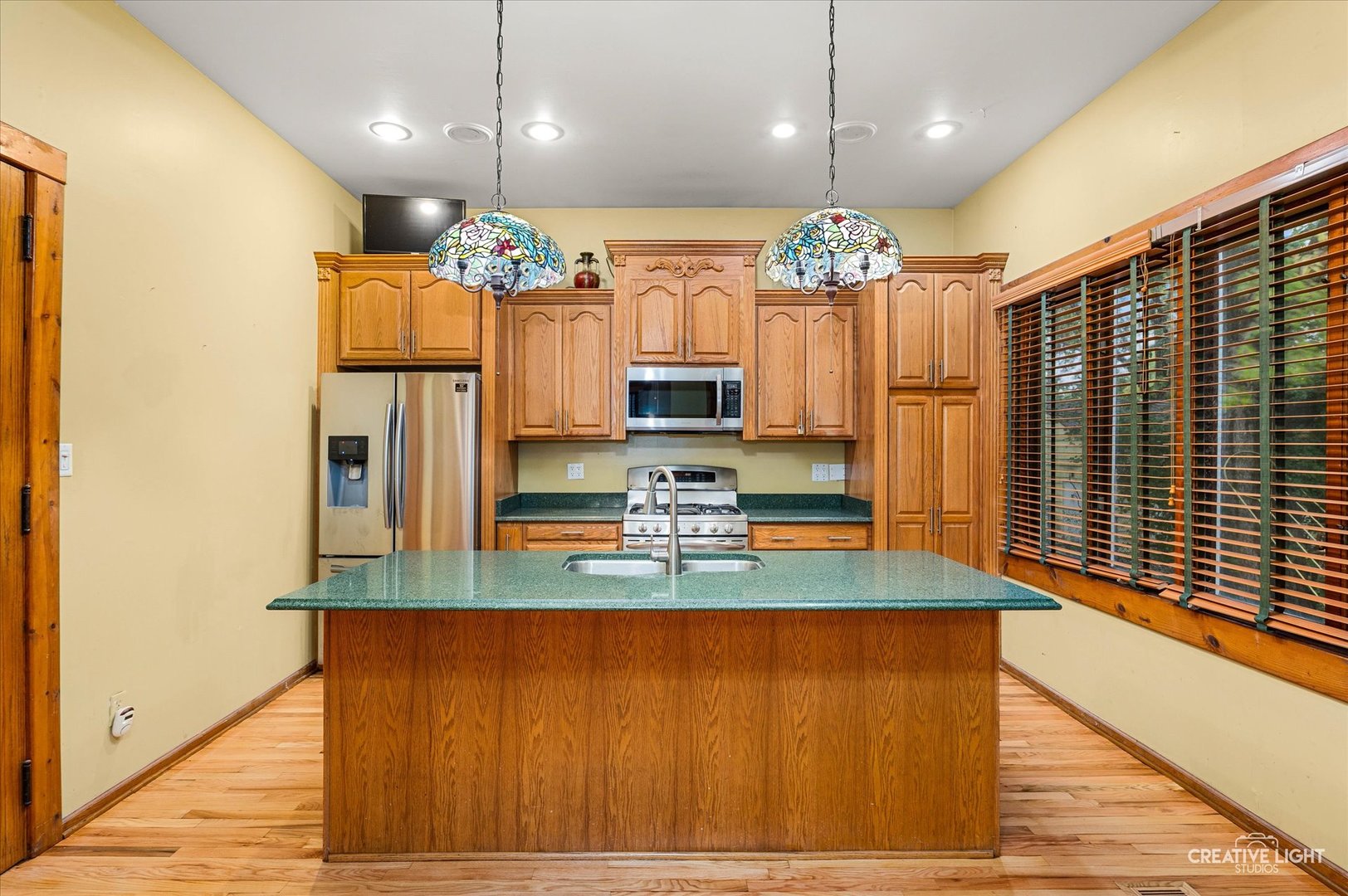 230 Comstock Street Joliet, IL 60436 - Photo 2 of 21 a kitchen with kitchen island granite countertop a stove and a wooden floor