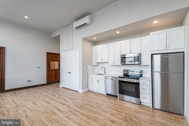 a kitchen with stainless steel appliances granite countertop a refrigerator and a stove top oven