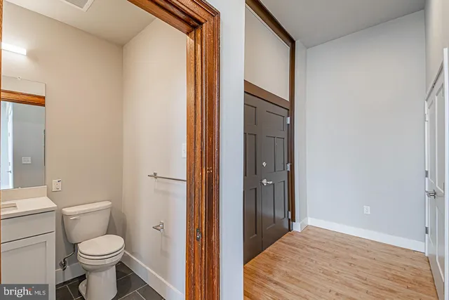 a bathroom with a granite countertop toilet and a sink