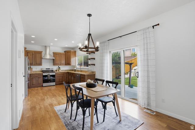 2007 Fielding Hill Lane Draper, UT 84020 - Photo 13 of 83 Open-concept dining area featuring wood-finish flooring, a modern chandelier, and direct access to the outdoor space via sliding glass doors