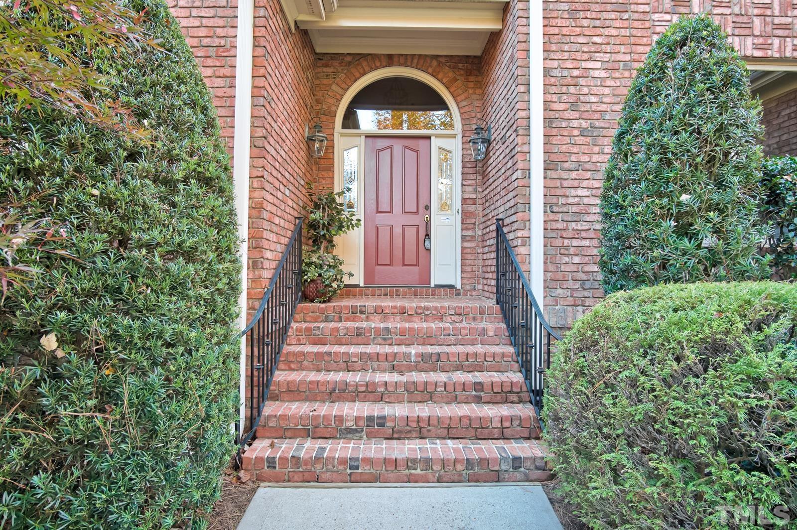 616 Bent Ridge Place Raleigh, NC 27615 - Photo 2 of 28 a view of a brick house with plants and large trees