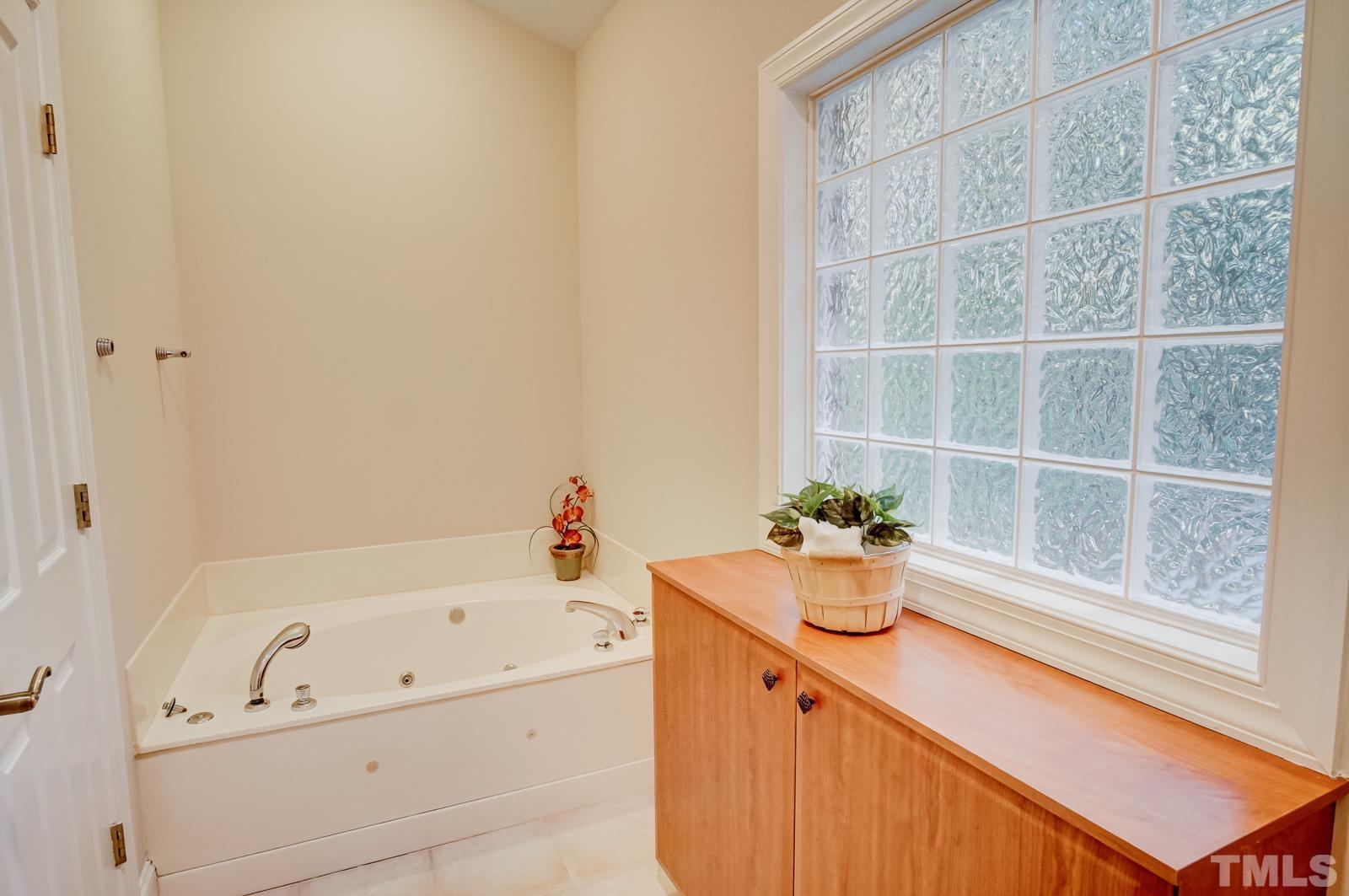 616 Bent Ridge Place Raleigh, NC 27615 - Photo 15 of 28 a bathroom with a bathtub sink and window