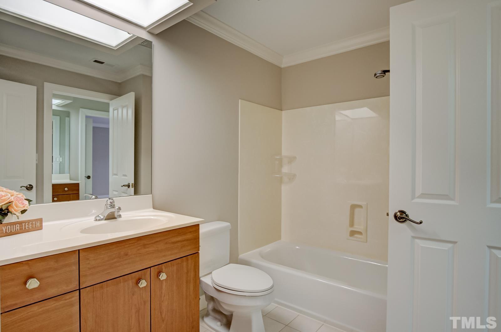 616 Bent Ridge Place Raleigh, NC 27615 - Photo 19 of 28 a bathroom with a sink a toilet and a mirror