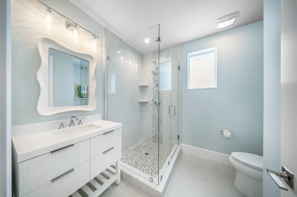 a bathroom with a sink a toilet and shower