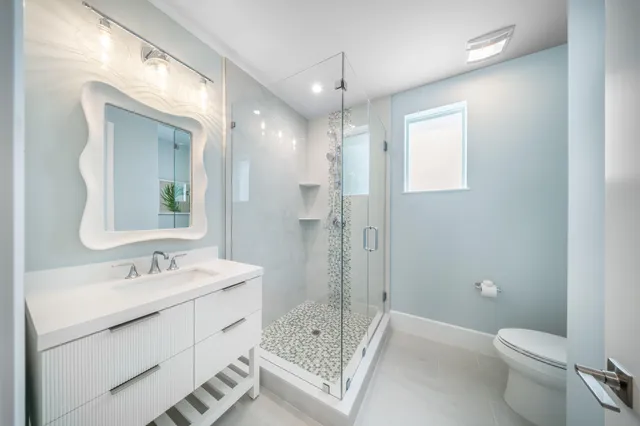 a bathroom with a sink a toilet and shower