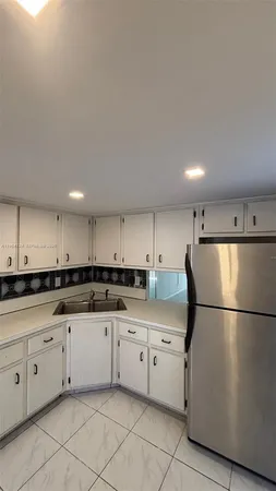 a kitchen with white cabinets and white appliances