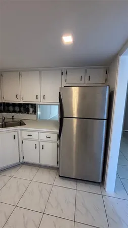 a kitchen with cabinets and a refrigerator