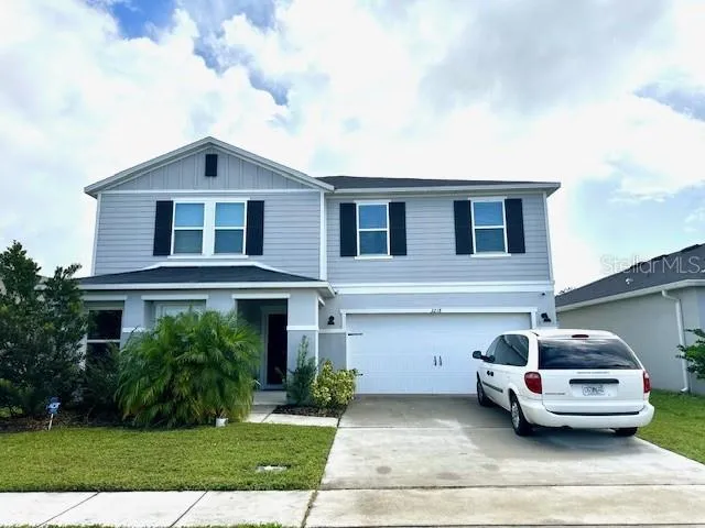 a car parked in front of a house with a yard