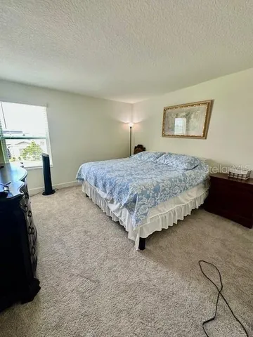 a bedroom with a bed and dresser with window