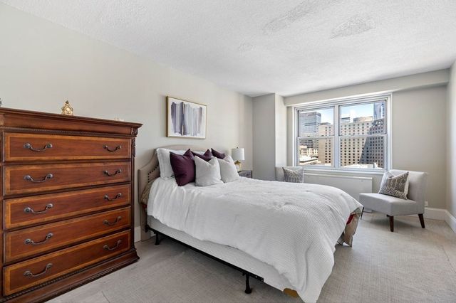 a bedroom with a bed and a large window
