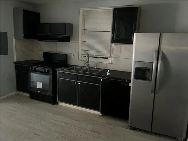 a kitchen with a refrigerator and a stove top oven