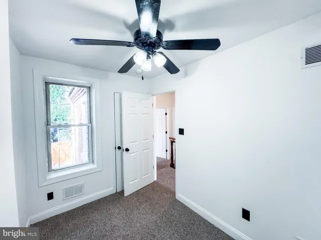 en empty room with window and ceiling fan