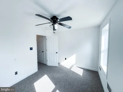a view of room with a ceiling fan and a window