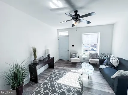 a living room with furniture ceiling fan and a window