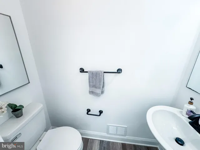 a bathroom with a sink a toilet and mirror