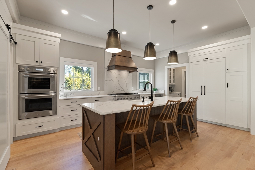 1102 Massachusetts Avenue Lexington, MA 02421 - Photo 11 of 42 a view of kitchen with stainless steel appliances kitchen island granite countertop a stove a sink a refrigerator and a wooden floor