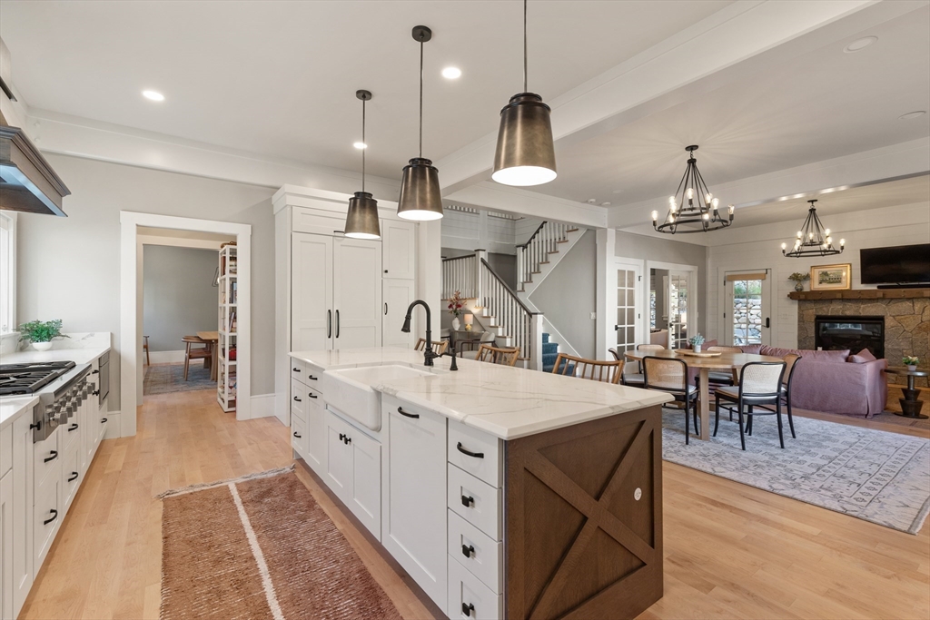 1102 Massachusetts Avenue Lexington, MA 02421 - Photo 12 of 42 a large white kitchen with sink a stove and chairs