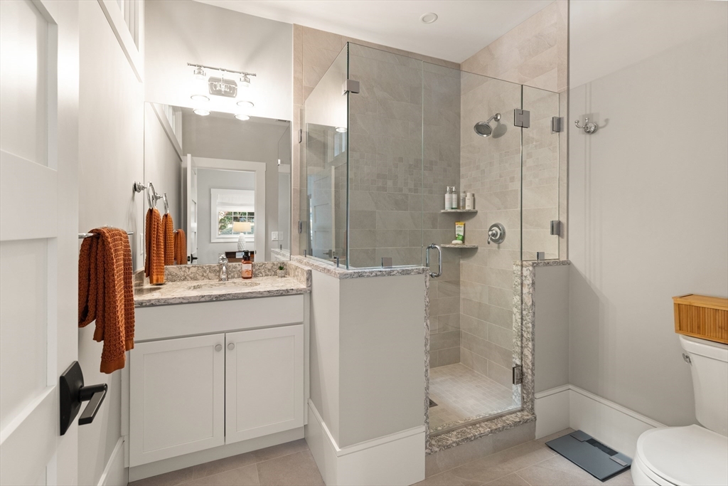 1102 Massachusetts Avenue Lexington, MA 02421 - Photo 26 of 42 a bathroom with a granite countertop sink toilet and shower