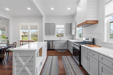 a bedroom with a bed and a large window with wooden floor