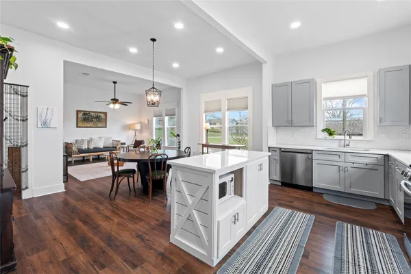 a kitchen with stainless steel appliances a sink stove cabinets and a wooden floor