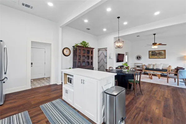 a kitchen that has a lot of white cabinets and wooden floor