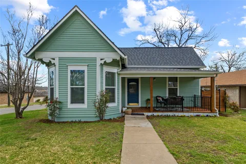 a front view of a house with a garden and porch